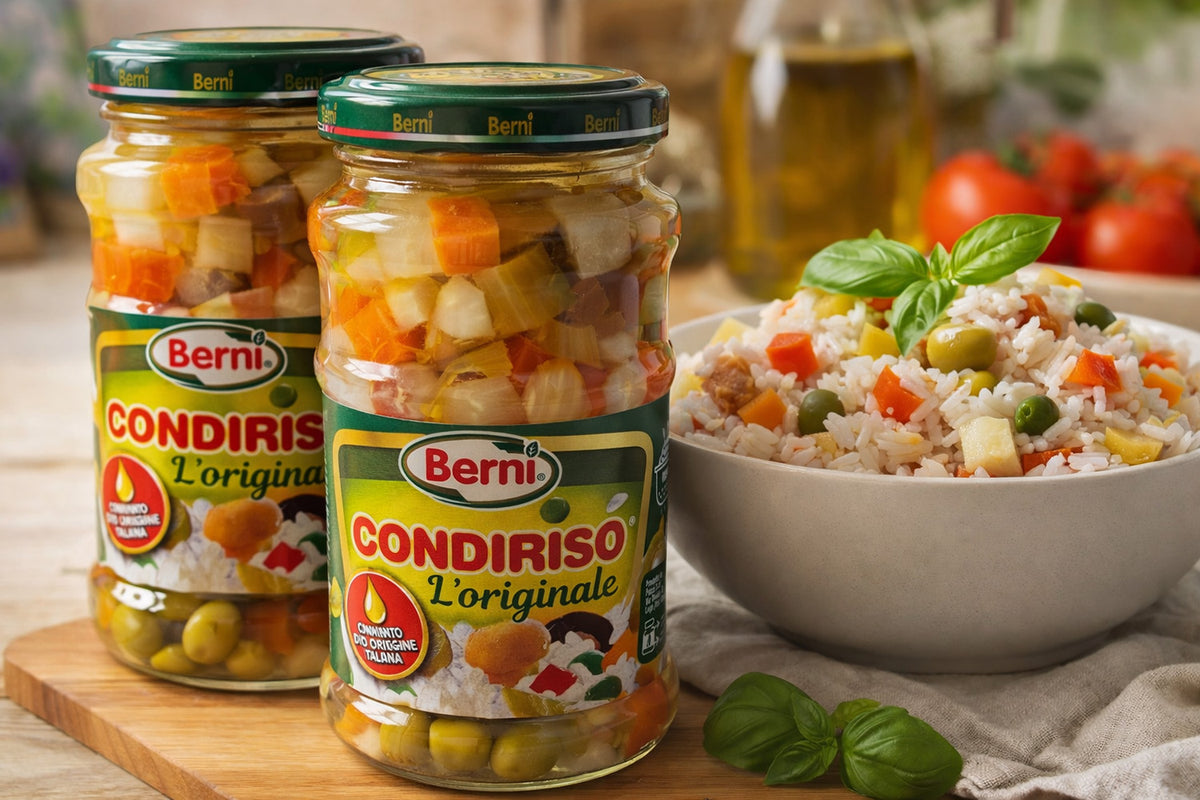 Two jars of Berné Condiriso with a bowl of salad on a wooden surface.