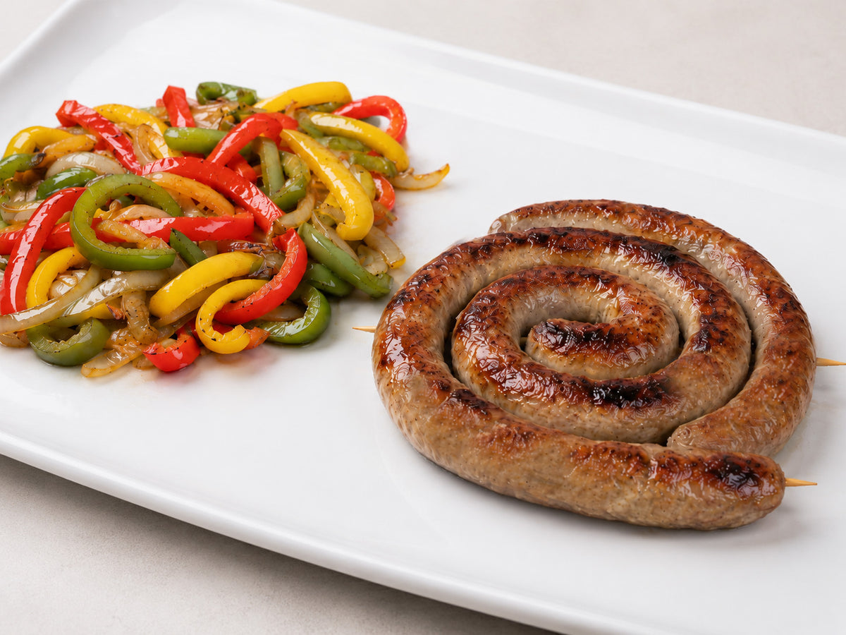 Sausage and Peppers - Cheese and Parsley sausage wheel on a platter with delicate sliced peppers and onions. 