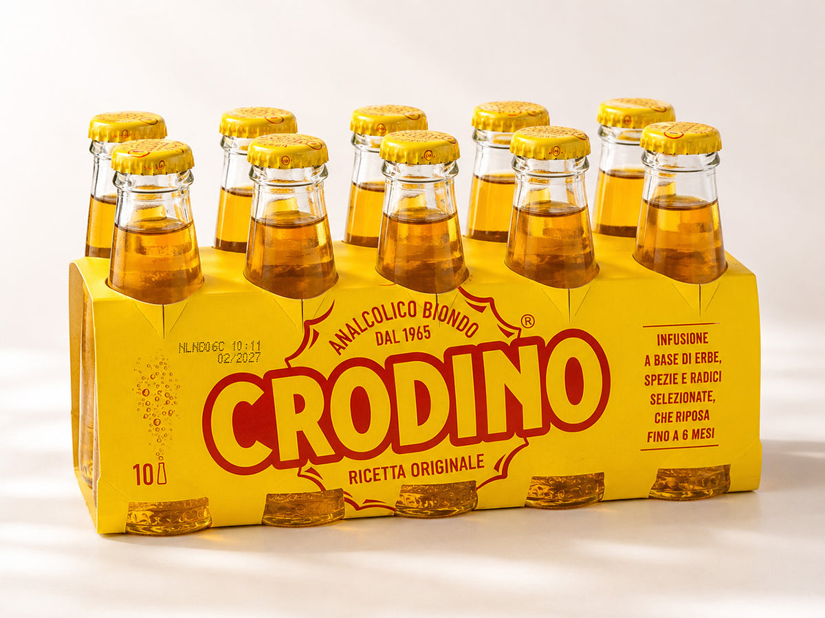 A 10-pack of Crodino non-alcoholic aperitif glass bottles in a yellow cardboard carrier, photographed on a clean white background.