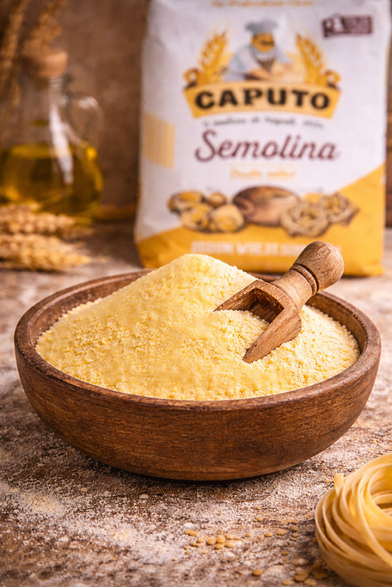 Wooden bowl of semolina with a scoop, Caputo Semolina bag in the background