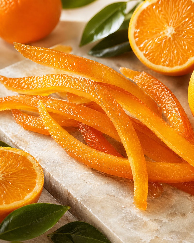 Candied Orange Peel on a white background with cut oranges 