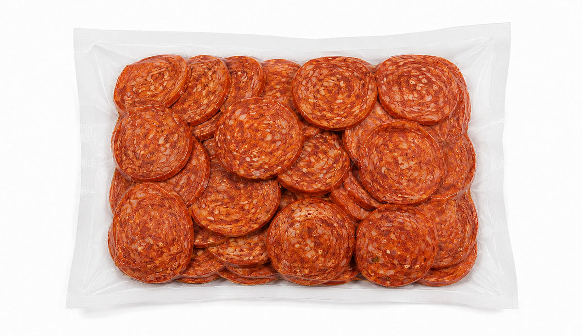A clear plastic bag filled with sliced red pepperoni rounds, photographed from above on a plain white background.